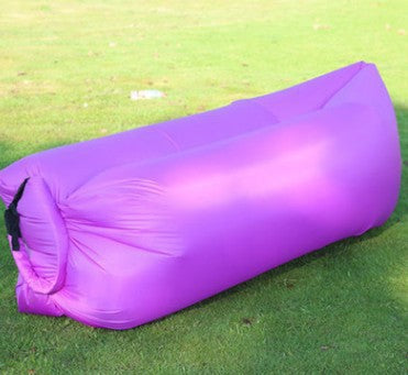 Purple inflatable sleeping pad on grass