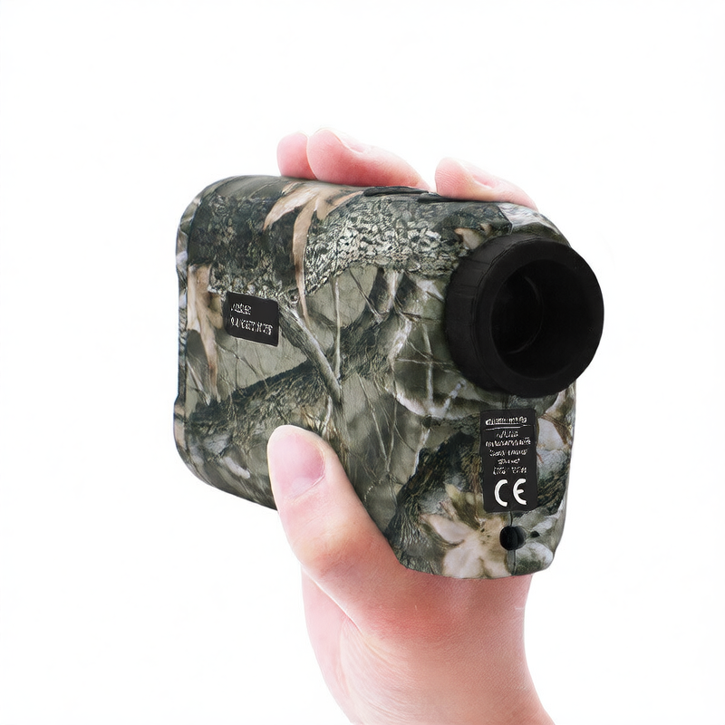 Camo-patterned laser rangefinder held in a hand against a white background