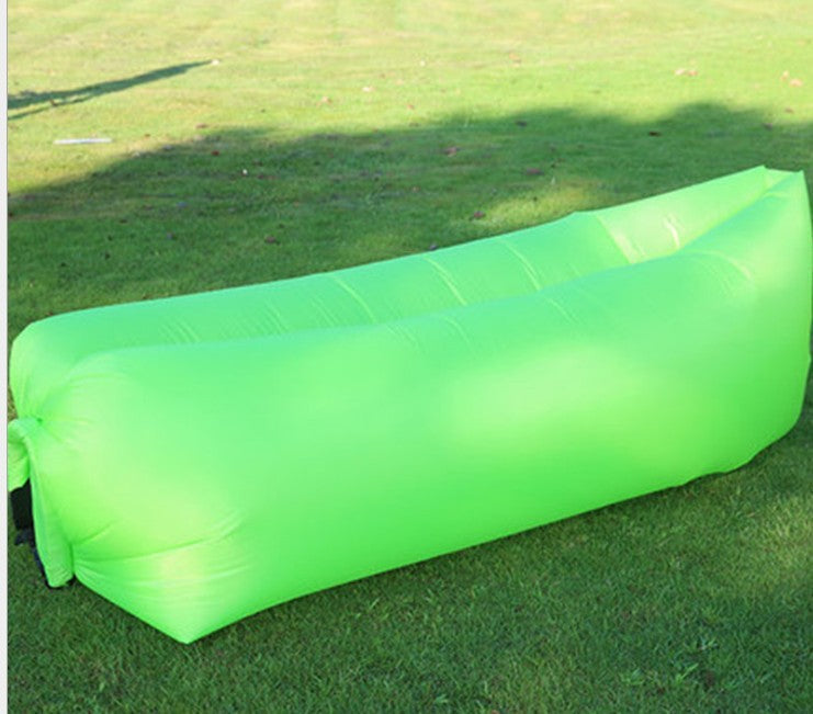 Green inflatable sofa on grass